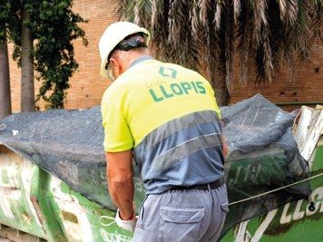Operario de Llopis con una cuba de residuos de construcción y demolición